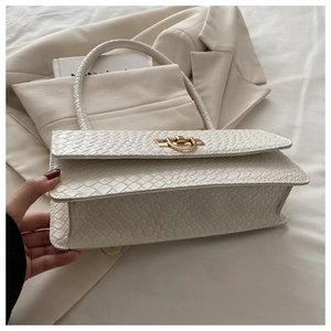 Detail of white stone textured handbag with golden round metal lock and woven handle