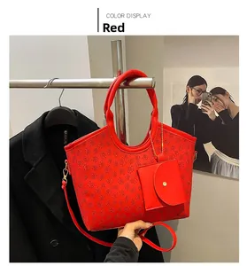 Detail of red tote bag with embossed clover pattern and matching small magnetic pouch