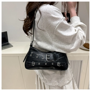Detail of black punk shoulder bag featuring silver rivets and eyelet straps