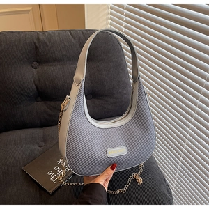 Detailed shot of blue woven texture handbag with Miss mini logo and golden chain strap