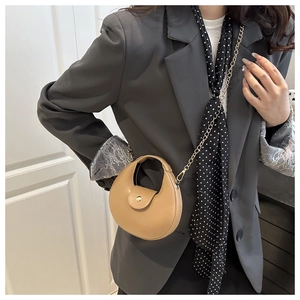Detail of khaki crescent shoulder bag with matte leather finish and golden chain strap