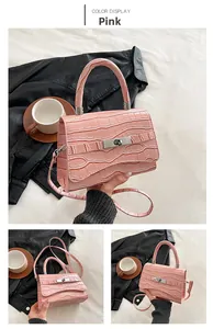 Pink croc-embossed small crossbody bag featuring a golden twist lock and top handle