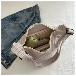 Detail view of large corduroy crossbody bag interior showing spacious storage capacity