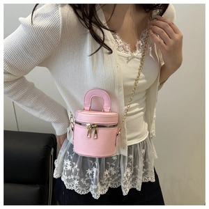 Vue détaillée du mini sac cylindre rose avec double fermeture éclair et chaîne dorée