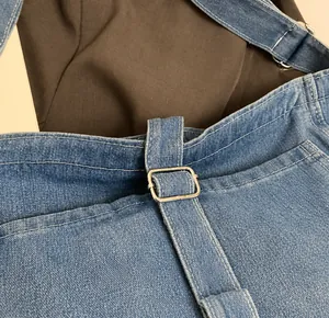 Detailed close-up showing the sturdy silver metal buckle on a light blue denim tote bag