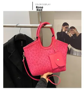 Detailed close-up of rose red tote bag featuring embossed clover patterns and mini pouch