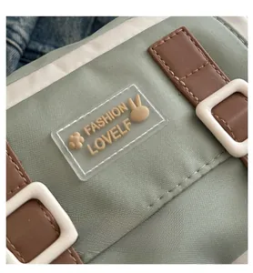 Detail van groene nylon tas met modelabel en bruine lederen afwerking op de stof