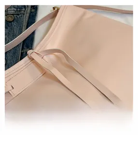 Close-up of pink leather tote bag showing fine stitching and smooth material texture
