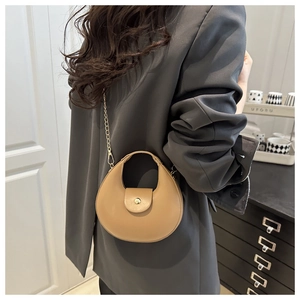 Detail of a chic crescent bag with gold chain strap and smooth beige leather texture