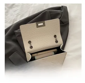 Internal capacity of beige crocodile pattern bag holding a phone and wallet