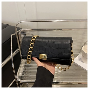 Détail du sac à rabat noir motif pierre avec chaîne dorée et fermoir métallique chic