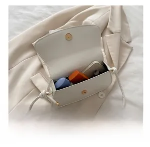 Vue détaillée de la capacité d'un sac bandoulière en cuir crème avec fermoir nœud