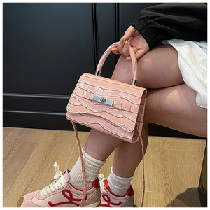 Detailed look at the pink faux crocodile leather texture and silver metal twist lock