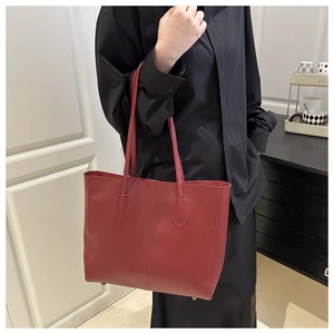 Detailed side view of a large vintage dark red tote bag on model for daily commuting