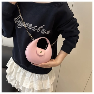 Detailed macro of pink half-moon shoulder bag with gold clasp and chain strap