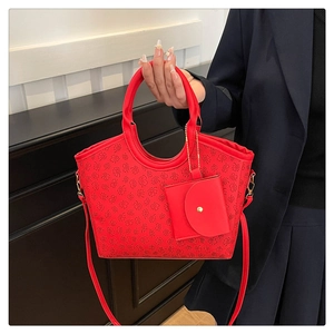 Detail of red clover-patterned tote bag with small square pouch and gold hardware
