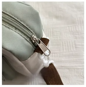 Detail van de gladde rits en nylon stof op de groene crossbodytas voor vrouwen