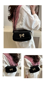 Détail d'un sac bandoulière élégant en cuir noir avec un fermoir nœud doré chic