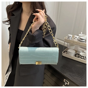 Détail du sac bleu clair en similicuir crocodile avec bandoulière chaîne dorée