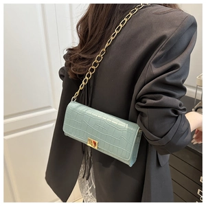 Détail du sac à main vert menthe gaufré avec chaîne dorée et fermoir carré élégant