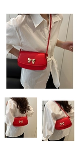 Gros plan d'un mini sac rouge bandoulière avec boucle de nœud doré poli brillant