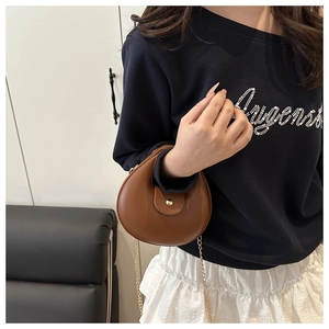 Détail du sac dumpling marron avec chaîne dorée et boucle métallique circulaire