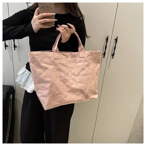 Pink tote bag detail with crinkled texture, lacquer finish, and TOTE BAG lettering