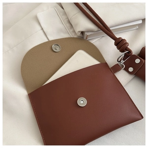 Detail of brown leather bucket bag showing lychee texture and silver magnetic closure