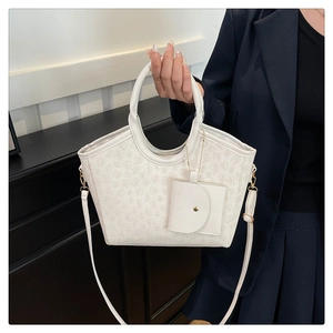 Detail of cream clover embossed tote with matching mini round coin purse and gold hardware