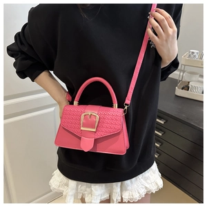 Detail of rose red crossbody bag with woven texture flap and golden square buckle