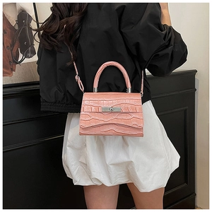 Detail of pink croc-embossed handbag showing silver twist lock and versatile carry straps