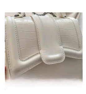Detailed view of cream-white crocodile texture leather flap bag with metal chain strap