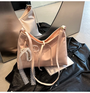 Chic light pink tote bag featuring elegant lace ribbon and pearl charm detail