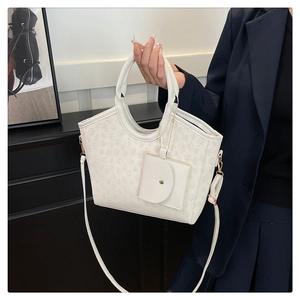 Detailed view of white tote bag set with floral embossing and round coin purse attachment