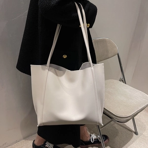 Minimalist large white leather tote bag with contrast stitching shown on a model