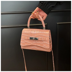 Detailed close-up of pink croc-embossed handbag with silver twist lock and handle