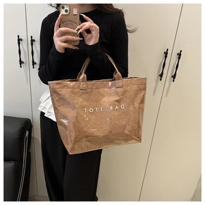 Detail of waterproof brown tote bag with TOTE BAG print and textured paper interior