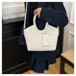 Detail of cream tote bag with floral pattern, matching mini pouch, and shoulder strap