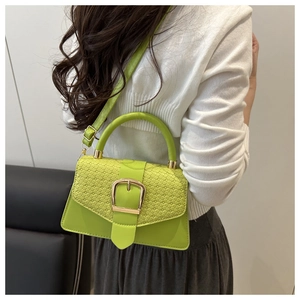 Détail du sac à main vert citron en cuir avec rabat crocodile et grande boucle dorée