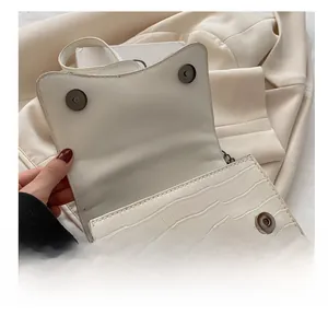 Close-up of white crocodile pattern bag with premium magnetic metal clasp detail