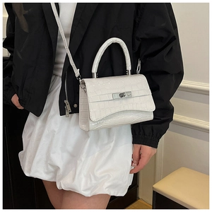 Detail view of white crocodile pattern handbag with elegant silver metal twist lock buckle