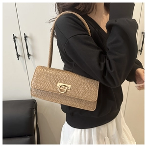 Detail of tan crocodile embossed texture and golden D-ring buckle on French baguette bag