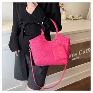 Detail of hot pink tote bag featuring clover embossed pattern and matching mini pouch