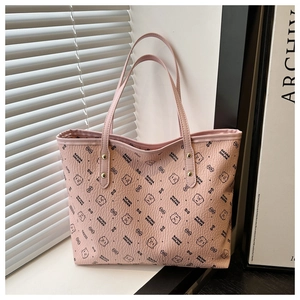 Detail of pink leather tote bag with bear print, lychee texture, and gold rivets