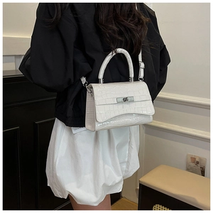 Rear view of a model carrying a white crocodile texture crossbody bag with silver hardware