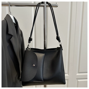 Detail of black PU leather bucket bag with matching mini pouch and decorative knot