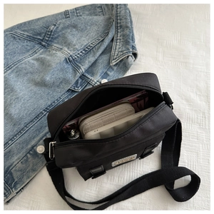 Internal view of a black nylon crossbody bag showing spacious capacity for daily items