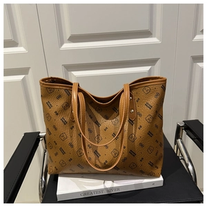 Détail du sac cabas en cuir marron texturé avec imprimés d'ours noirs et lettrage de marque