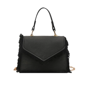 Borsa a mano nera alla moda con frange in denim e catena dorata con una forma a trapezio