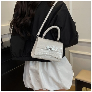 Detail of cream stone texture handbag with silver twist lock and detachable strap